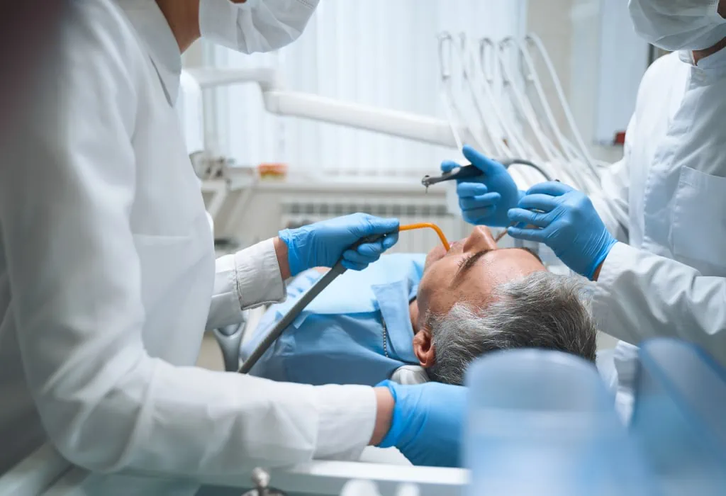 Anzeichen einer Parodontitis - Mann bei der Behandlung beim Zahnarzt